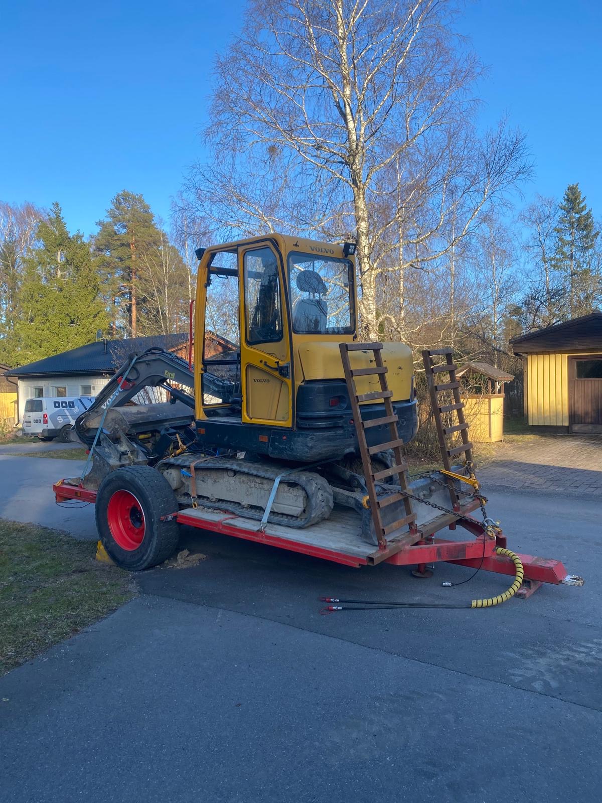 Kaivinkone asiakkaan pihalle kaivamaan kantoja ylös